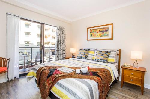 um quarto com uma cama com uma mesa e uma janela em Perth City Living 105 em Perth