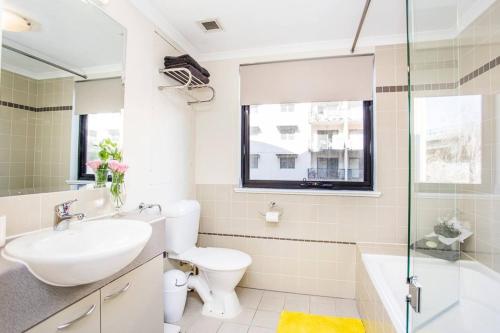 uma casa de banho com um lavatório, um WC e uma banheira em Perth City Living 105 em Perth
