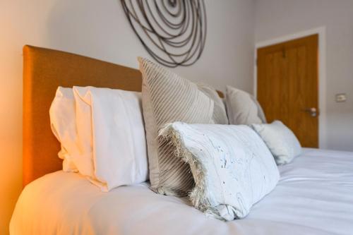 a bed with white pillows on top of it at Long Eaton Modern 4bed House in Long Eaton