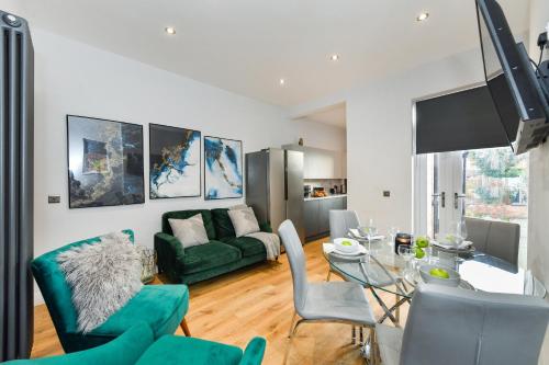 a living room with a green couch and a glass table at Long Eaton Modern 4bed House in Long Eaton