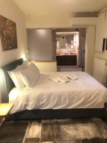 a large white bed in a room with a bathroom at Valeni Boutique Hotel & Spa in Portariá