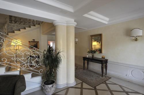 a lobby with a staircase with columns and a table at Hotel Ristorante La Lampara in Gizzeria