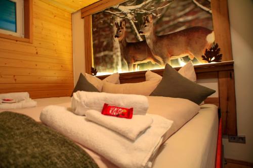 a room with a bed with towels and a picture of deer at Erholsame 2 Zimmer FeWo mit King-Size-Bett, Pool und Stellplatz in Baiersbronn