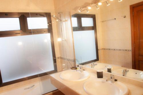 a bathroom with two sinks and a shower and a mirror at El jardín de Juanita - ROOMS in Playa Blanca