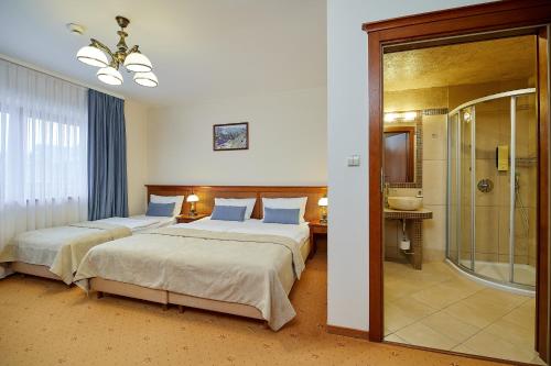 pokój hotelowy z dwoma łóżkami i prysznicem w obiekcie Hotel Burkaty w mieście Białka Tatrzanska