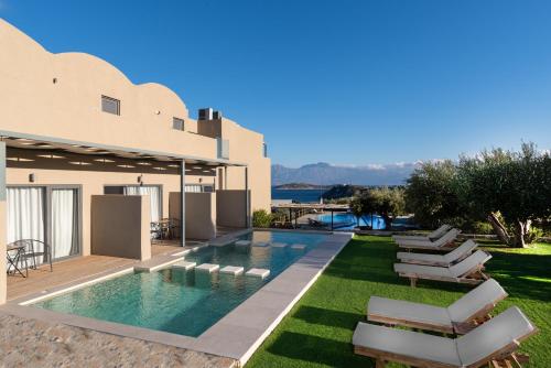 a villa with a swimming pool and lawn at Meliti Hotel (Adults Only) in Agios Nikolaos