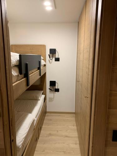 a room with two bunk beds and a hallway at Des Alpes C Flat 11 in Madonna di Campiglio