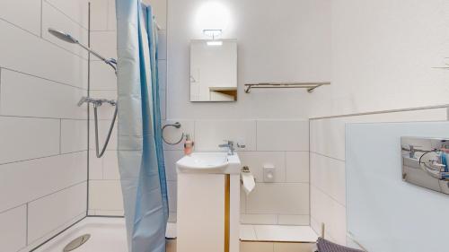 a bathroom with a sink and a shower at Anstatthotel Affoltern am Albis - self-check-in in Affoltern