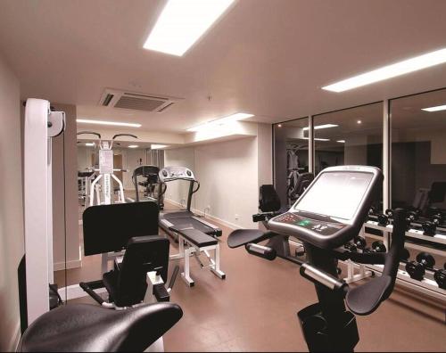 a gym with several machines and mirrors in a room at Melbourne Luxury Penthouse in prime location in Melbourne