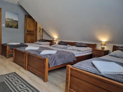 three beds in a room with a staircase at Pokoje u Hani - sauna, balia z hydromasażem in Bukowina Tatrzańska