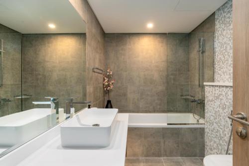 y baño con bañera y lavamanos. en Vacay Lettings - Waterfront Luxury home with full Marina view, en Dubái