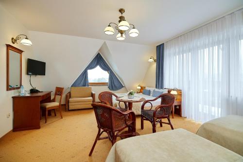 a hotel room with a table and chairs and a bedroom at Hotel Burkaty in Białka Tatrzanska