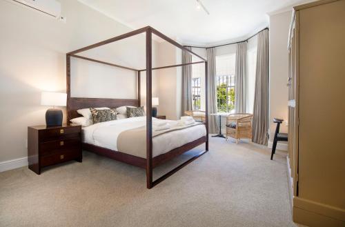 1 dormitorio con 1 cama grande y espejo grande en Middedorp Manor, en Stellenbosch