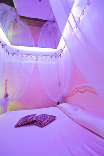 a pink bedroom with two pillows on a bed at Vip's Motel Luxury Accommodation & Spa in Lonato del Garda