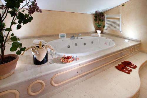 a large bathroom with a tub with a plant at Vip's Motel Luxury Accommodation & Spa in Lonato del Garda