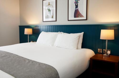 a hotel room with a white bed and two lamps at The Caledonian Hotel in Leven-Fife