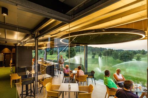 a restaurant with people sitting at tables and a large window at Metzenhof in Kronstorf