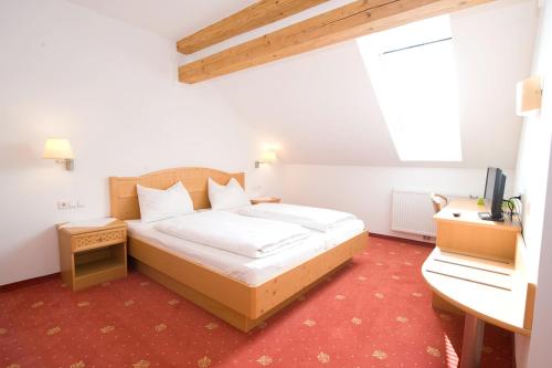 Schlafzimmer mit einem Bett, einem Schreibtisch und einem TV in der Unterkunft Metzenhof in Kronstorf