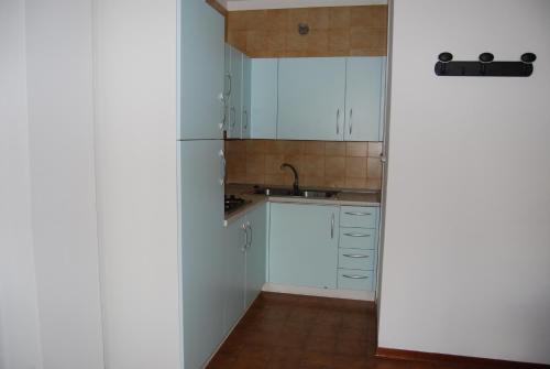 a kitchen with white cabinets and a sink at Condominio San Michele in Bibione