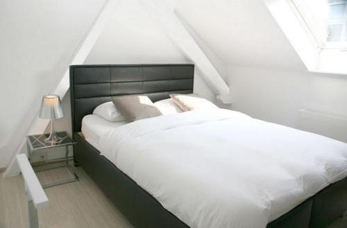 1 dormitorio con 1 cama grande con sábanas y almohadas blancas en VISIONAPARTMENTS Cramerstrasse 8-12 - contactless check-in, en Zúrich