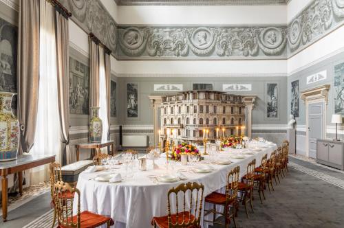 una lunga sala da pranzo con un lungo tavolo e sedie di No Other Place - Palazzo Storico a Vicenza
