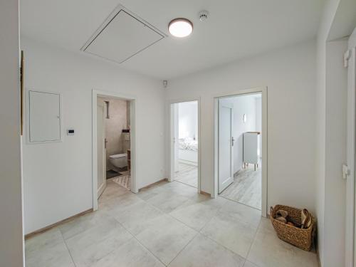 a room with white walls and a hallway with a mirror at Chalets New Apartmány Ivachnová in Ivachnová