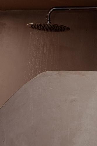 a shower head with water coming out of it at Meliti Hotel (Adults Only) in Agios Nikolaos