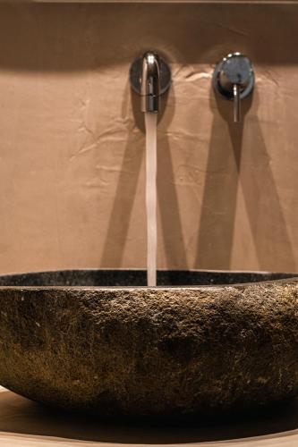 a stone sink with water coming out of it at Meliti Hotel (Adults Only) in Agios Nikolaos