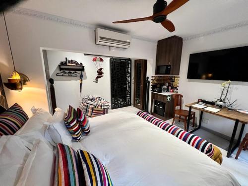 a bedroom with a large white bed with a ceiling fan at Forty 4 On Hoog in Polokwane