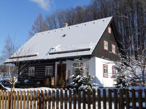 a black and white house with a snow covered roof at Penzion Roubenka in Hukvaldy