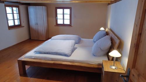 a large bed in a room with two windows at Schwarzwaldstube in Titisee-Neustadt