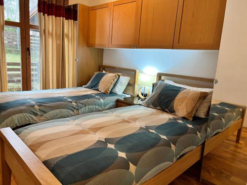1 dormitorio con 2 camas y ventana en Wood Apartment in Mountain View Complex, en Bansko