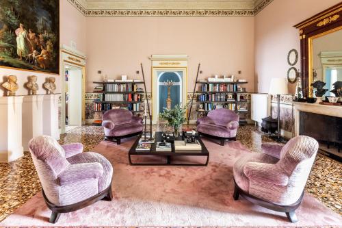 sala de estar con sillas de color púrpura y mesa en No Other Place - Palazzo Storico, en Vicenza