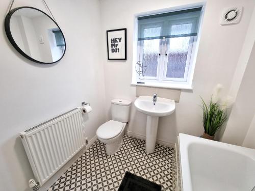a bathroom with a toilet and a sink and a mirror at Modern & Spacious 3 bedrooms and 2 bathrooms Home, Free Parking! in Cambridge