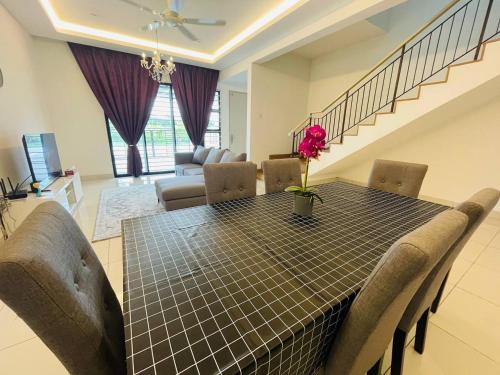 einen Esstisch und Stühle im Wohnzimmer in der Unterkunft Homestay 3BR near Setia Alam in Shah Alam