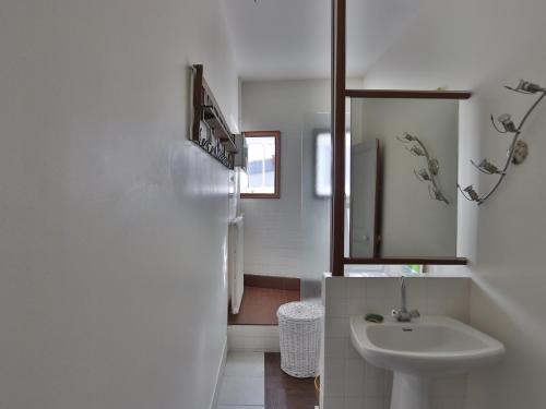 uma casa de banho branca com um lavatório e um espelho em Maison Les Sables-d'Olonne, 6 pièces, 12 personnes - FR-1-197-447 em Les Sables-dʼOlonne