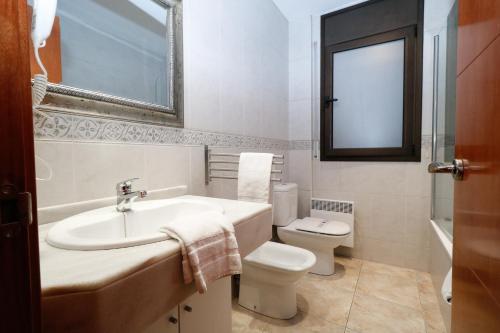 a white bathroom with a sink and a toilet at Apartamentos Degas MIKKA 3000 in El Tarter