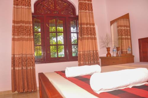 a bedroom with two beds and a window at Himashi Sea View Homestay in Gandara East