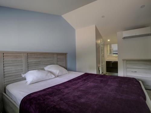 a bedroom with a large bed with a purple blanket at Villa 5 chambres à Biscarrosse avec piscine chauffée, wifi, proche océan - FR-1-521-18 in Biscarrosse-Plage