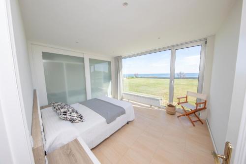 a bedroom with a bed and a large window at Apartagal- Casa Playa, Foz in Foz