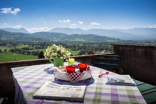 a picnic table with a table cloth and a basket of food at City Center Apartments - Happy Rentals in Spello