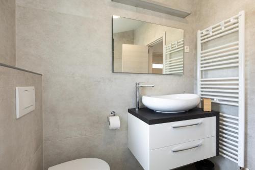 a bathroom with a white sink and a mirror at Apartments Villa Padrone with pool - perfect for families! in Garica