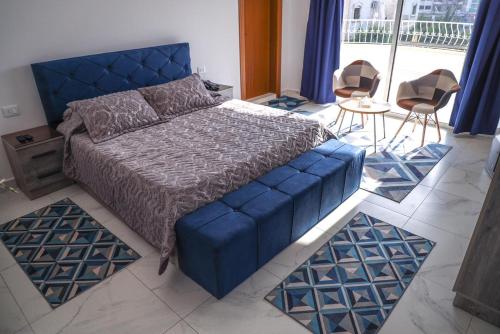 a bedroom with a blue bed and two chairs at Reef Zefta Hotel in Zefta