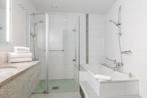 a white bathroom with a shower and a sink at Break Sokos Hotel Flamingo in Vantaa