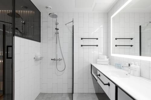 a white bathroom with a shower and a sink at Break Sokos Hotel Flamingo in Vantaa