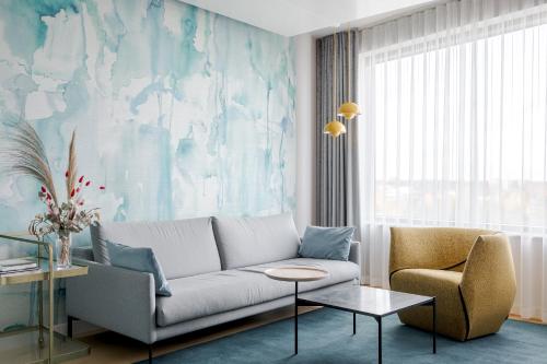 a living room with a couch and a chair at Break Sokos Hotel Flamingo in Vantaa