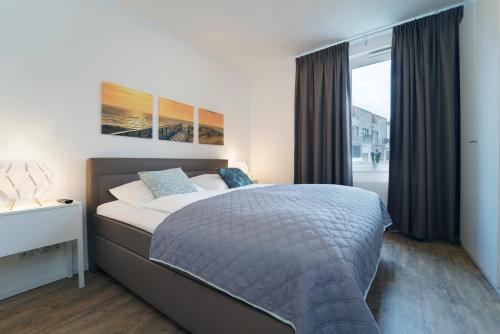 een slaapkamer met een groot bed en een raam bij KellenHus Wohnung 3 in Kellenhusen