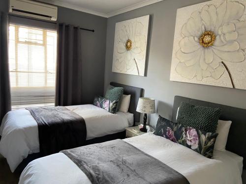 a bedroom with two beds and a window at Karoo Heart in Beaufort West