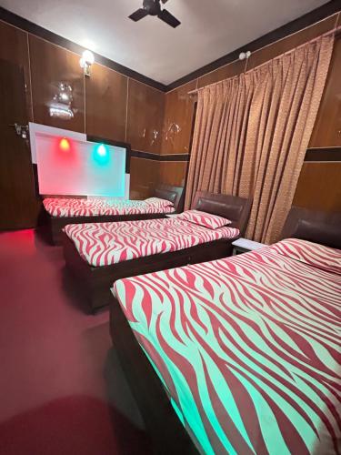 a hotel room with two beds with red and green stripes at Sudha’s Garden Home in Kathmandu