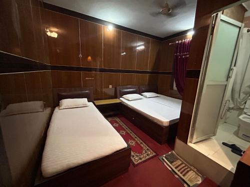Cette petite chambre comprend deux lits et une douche. dans l'établissement Sudha’s Garden Home, à Katmandou